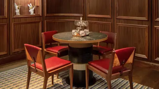 a wooden paneled room with a table and chairs