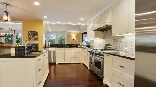 a kitchen with white cabinets and stainless steel appliances