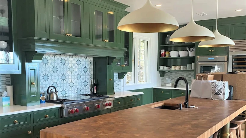 Remodeled kitchen with unique green cabinets and a butcher block island
