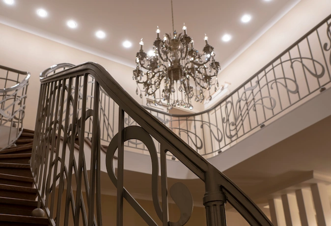 luxury staricase with custom wood trim molding and ornate railing