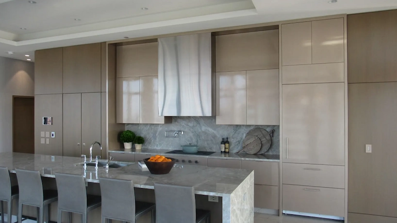Beautiful modernized kitchen with built in fridge and a polished stone island